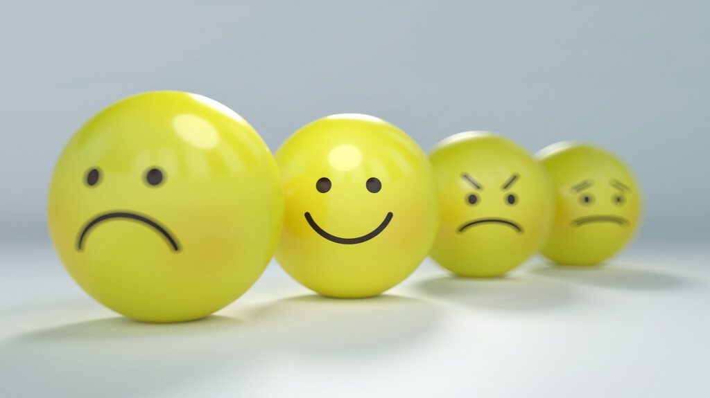 Vier gelbe Smiley-Bälle mit unterschiedlichen Gesichtsausdrücken.